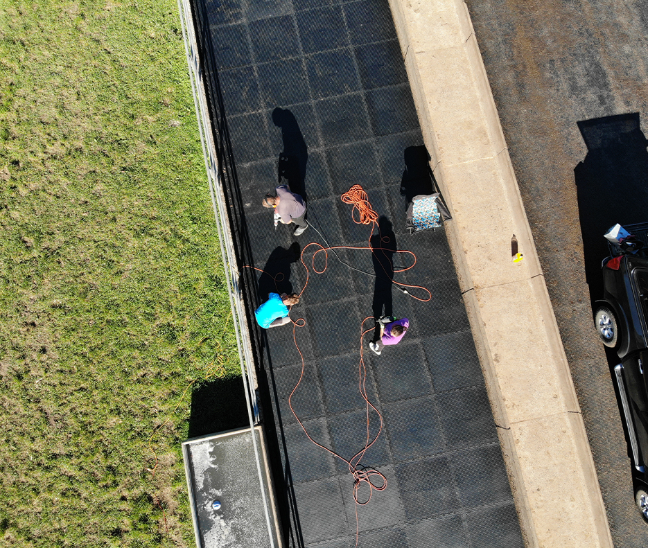 3 people installing Penny Grip Tiles on a farms feeding pad
